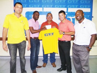 Customer Service Representative of GT&T, Quinsbert Tyndall (second from left) presenting GRFU head, Peter Green with a $500,000 cheque to aid the ruggers with their airfare and accommodation for the NACRA Sevens next month in the Cayman Islands.  
