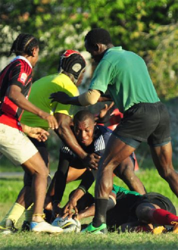 Some of the national ruggers going at it during one of the warm up games yesterday at National Park rugby field. (Orlando Charles photo) 