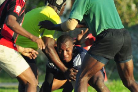 Some of the national ruggers going at it during one of the warm up games yesterday at National Park rugby field. (Orlando Charles photo) 