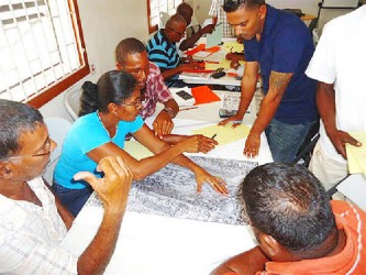 Participants pour over a map during the entry level training for prospectors in the extractive industry. 