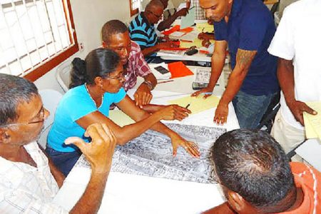 Participants pour over a map during the entry level training for prospectors in the extractive industry.
