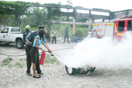 An AINLIM employee learning how to use the fire extinguisher
