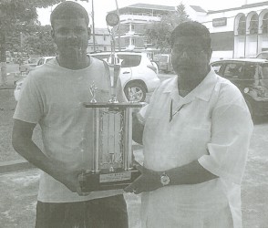 Khemraj Poranmall, left and Jairam, show off the first place trophy for this weekend’s national draughts championships.