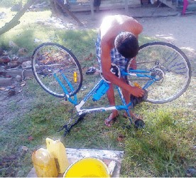 A young man cleaning his bicycle