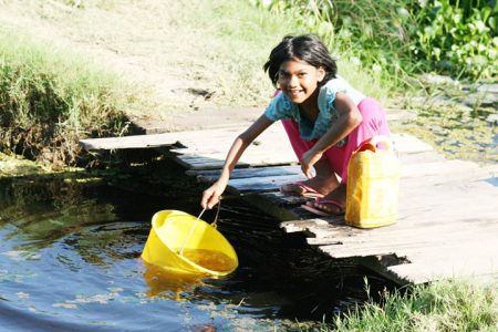 This young girl was fetching water from the
trench in front of her yard to complete her yard chores.