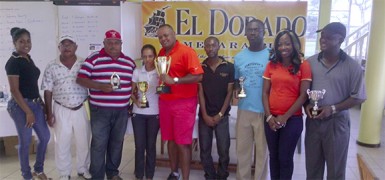 Troy Cadogan and Christine Sukhram, centre, show off the first and second place trophies following Saturday’s El Dorado Classic golf tourney at the Lusignan Golf Club. 