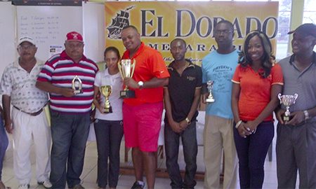Troy Cadogan and Christine Sukhram, centre, show off the first and second place trophies following Saturday’s El Dorado Classic golf tourney at the Lusignan Golf Club.
