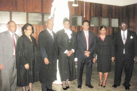 Naomi Christie is flanked by, from left, Agriculture Minister Dr Leslie Ramsammy, Solicitor Evelyn Sita Ramlal and Justice Brassington Reynolds, and from right, Rockcliff and Pearl Christie and Attorney General Anil Nandlall.
