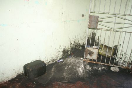 The entrance of the building blackened with tar and waste oil, while a corner of the entrance has become a miniature dumpsite. 