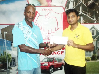 Coach of the Roberts Champions Boxing Gym, Jeff Roberts receiving the sponsorship cheque from Hand-in-Hand’s representative, Mark Samaroo yesterday.  