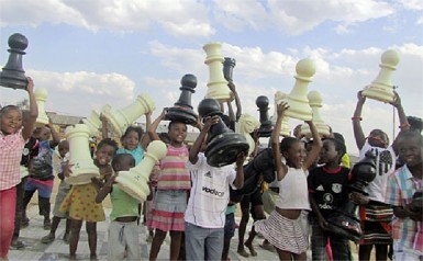 The smiling and happy faces of the children of Soweto, South Africa, as they hold giant chess pieces aloft! Last month, a delegation of German chess teachers and sponsors travelled to South Africa, as part of the FIDE Chess in Schools programme and the Kasparov Chess Foundation, which are engaged in introducing chess to schools all over the world. The advantages of introducing chess in schools have become clear to many countries of the world, and South Africa is one of them. The general goal of the German project is to educate teachers and adults on how to teach chess in schools, with the primary aim of spreading the beneficial virus of the royal game to various communities through the school system. 