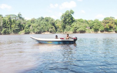 A young boy takes his sister home in their boat 