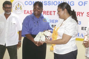 East Street Nursery’s Head Teacher Belinda Cameron receives the keys to the new school building from Education Minister Priya Manickchand