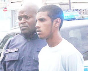 Murder accused Jonathan Johnson as he was escorted to the Port-of-Spain Magistrates Court yesterday. 