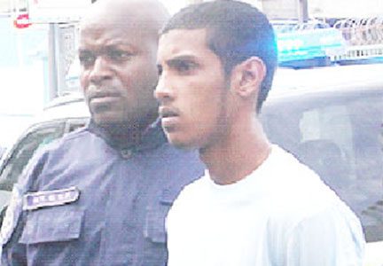 Murder accused Jonathan Johnson as he was escorted to the Port-of-Spain Magistrates Court yesterday. 