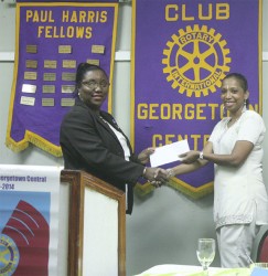 Georgetown Central Rotary Club President Judy Semple-Joseph (left) receives the cheque from Courts representative Molly Hassan. 