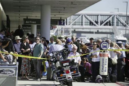 Delayed passengers stand behind a police cordon after a shooting incident at Los Angeles airport (LAX), November 1, 2013. REUTERS/Lucy Nicholson