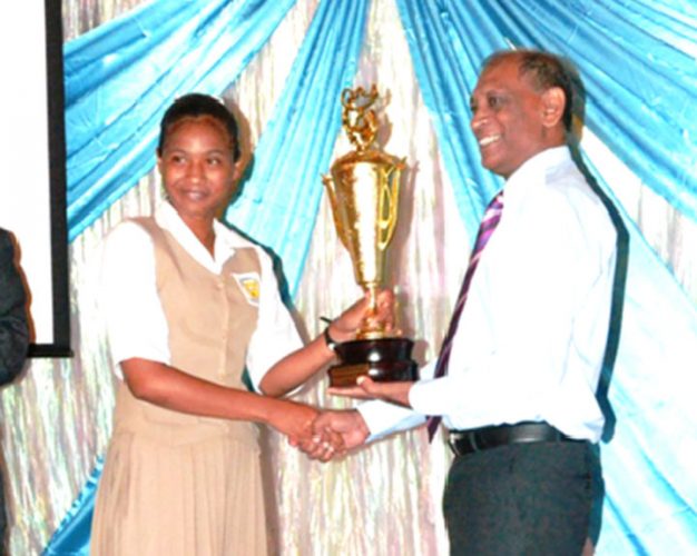 Minister of Agriculture, Dr Leslie Ramsammy presenting the overall award for the Best Pesticide Awareness Corner in a secondary school to a student of the Corentyne Comprehensive High School. (GINA photo) 