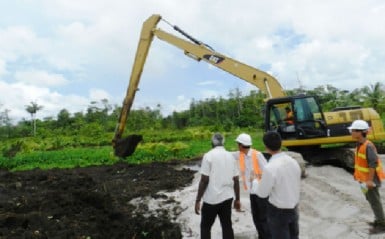  Minister of Works Robeson Benn (left) looking on at the excavation works ongoing at the CJIA on Thursday in the presence of officials from CHEC. 
