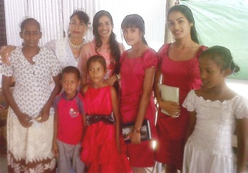 Proud mom Devika Persaud (second left) poses with her daughters and the recipients of the hamper they donated 