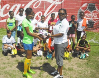 Vanessa Dickenson (right), President of the NAWF handing over the donated boots to club representative Aaliyah Stanley while other members look on. 