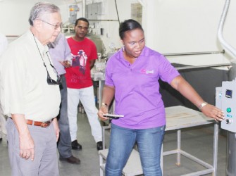 Sterling Products Limited (SPL) Chairman Dr Leslie Chin pays keen attention during a demonstration of operations at the Yo’great yogurt factory. (SPL photo)