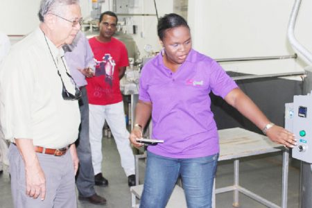 Sterling Products Limited (SPL) Chairman Dr Leslie Chin pays keen attention during a demonstration of operations at the Yo’great yogurt factory. (SPL photo)