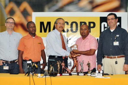 MACORP representatives Jordi Pinol, Damien Lewis (first and second from left) flank CEO Jorge Medina as he hands over the trophies to Lusignan Club Vice-President Dave Mohamed. MACORP Mining Major Accounts Manager Angel Rueda is pictured at right.
