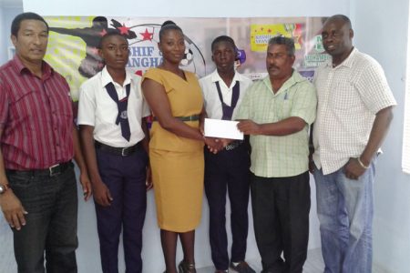 General Manager of the Bushy Park Sawmills, Patty Ramlall (second from right) hands over the sponsorship cheque to teacher and coach of the Uitvlugt Secondary School, Chevon Monchoir as students of the institution and co-founders of the K&S Organization, Kashif Muhammad (left) and Aubrey ‘Shanghai’ Major(right)  look on.