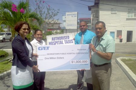GPHC’s CEO Michael Khan receives cheque for $1M from GT&T’s Marketing & Public Relations Director Roma Narayan-Singh. In background (L to R) are Nadia De Abreu, PRO of GT&T and Robbie Rambarran, Assistant Director of Finance at GPHC.
