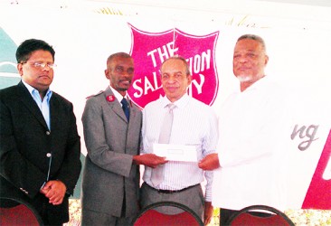 Prime Minister Samuel Hinds (right) handing over a cheque to Major Emmerson Cumberbatch of the Salvation Army at the launch of its Christmas Appeal 2013      