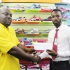 Giftland OfficeMax Public Relations Manager, Compton Babb hands over the stationery to Competitions Director of the National Schools’ Championships  Ceon Bristol (left).
