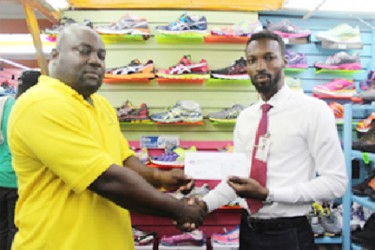 Giftland OfficeMax Public Relations Manager, Compton Babb hands over the stationery to Competitions Director of the National Schools’ Championships  Ceon Bristol (left).  