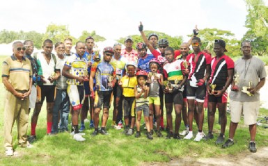 Winners and runners up pose with their spoils upon completion of yesterday’s inaugural C. Doekie and Sons Contracting Services, B&R Investment 11-race programme at the National Park. (Orlando Charles photo) 