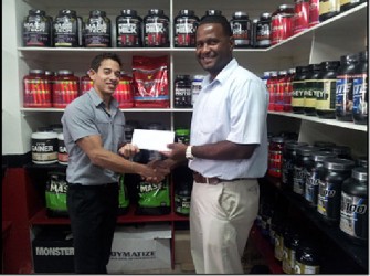 Organizing Secretary of the GAPF, Denroy Livan (right) receives a sponsorship cheque from Jamie McDonald to aid in Sunday’s Senior Powerlifting Championships.