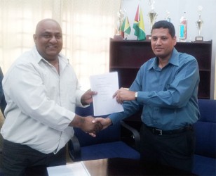 CEO of Natural Globe Inc Mohammed Osman (left) and Ministry of Local Government Permanent Secretary Collin Croal display the MOU.  