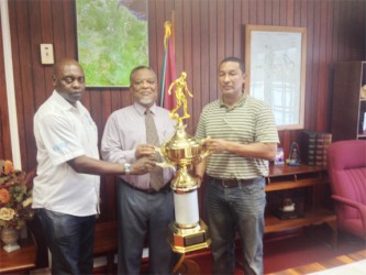 Prime Minister, Samuel Hinds (centre) presenting the championship trophy to co-founders of the K&S Organization yesterday at his office.  