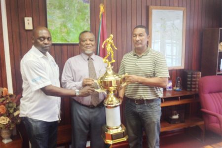 Prime Minister, Samuel Hinds (centre) presenting the championship trophy to co-founders of the K&S Organization yesterday at his office. 
