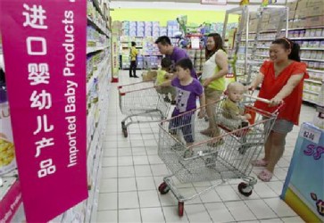 A family looks at foreign imported milk powder products at a supermarket in Beijing in this July 3, 2013 file photo. REUTERS/Kim Kyung-Hoon/Files 