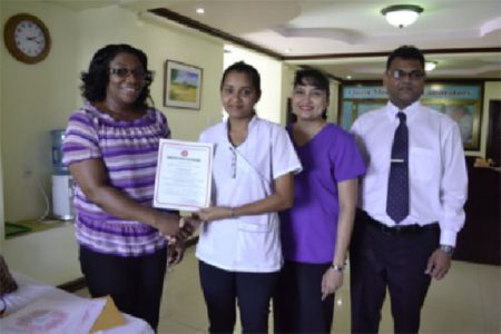 Director of GNBS, Evadnie Innis presents the Certificate of Compliance to Quest Medical Centre Laboratory Manager Kulwantie Mohabir who is accompanied by General Manager Ratna Budhu, and Medical Director Chetram Budhu. (Quest Medical Centre Laboratory photo)