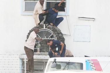 A medical staffer of the Dr Balwant Singh Hospital being rescued by police from a building next to the scene of the shooting. In the photo below a second staffer is being helped to safety.