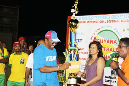 Ronald Evelyn captain of the victorious team receiving the trophy from Devi Sunich.