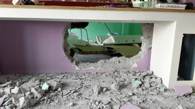 The sledged hole in the wall which enabled the police to get into the salon 