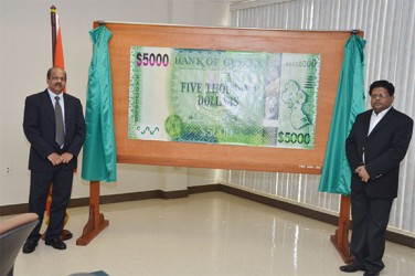 Deputy Governor of the Bank of Guyana Dr Gobind Ganga (at left) and Finance Minister Dr Ashni Singh unveil the new $5,000 note 