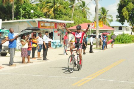 Team Coco’s Raynauth Jeffrey celebrating in customary fashion as he crosses the finish line in pole position of yesterday’s penultimate stage of the Tour of Guyana. (Orlando Charles photo)