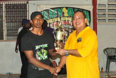 Vijai Rahim receiving the male best lifter trophy from president of the GAPF, Peter Green. (Orlando Charles photo) 