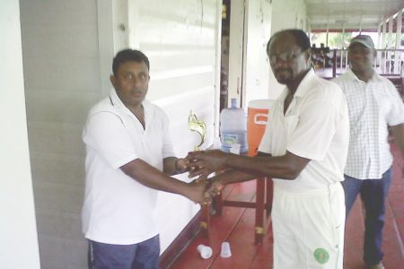  Man-of-the-match Surendra Heralall (left) receives his trophy from Sherlock `Zegger’ Atwell.