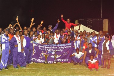 Athletes and officials of North Georgetown celebrating with their Champion-of- Champions trophy. (Orlando Charles photo)  