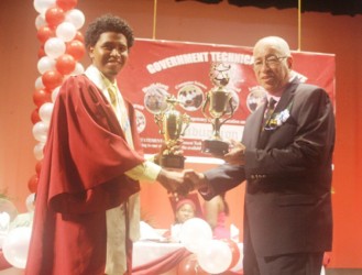Valedictorian, Colin Quintyn collects one of his many trophies from Chairman, GTI/GITC Board of Governor Norman McLean. (Government Information Agency photo)