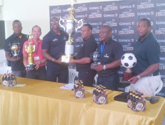 Petra Co-Director Troy Mendonca (right) collects the championship trophy from Banks DIH Limited Guinness Brand Executive Lee Baptiste while other members of the launch committee look on. 